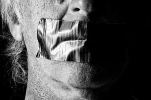 An image of a man with gaffer tape over his mouth